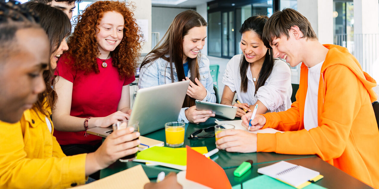 Young group of high school students studying together at cafeteria campus table